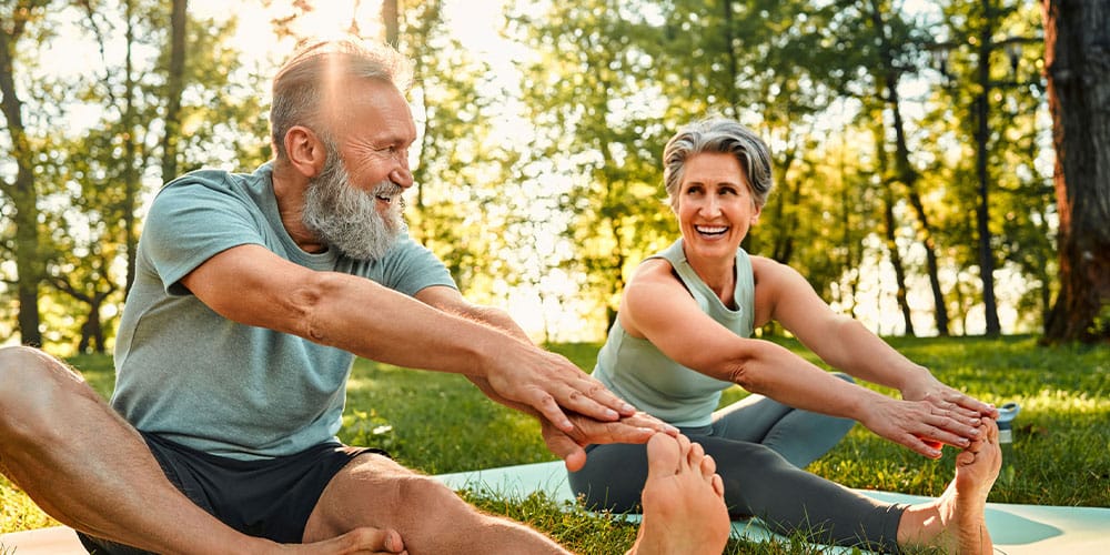 older couple in Denver stretching together after using integrative and holistic medicine techniques